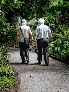 Man walking on path in Trompenburg Tuinen & Arboretum wearing white shirt and blue jeans