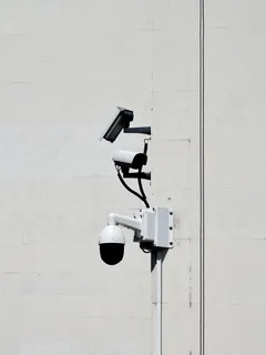 White CCTV cameras monitoring outdoors during daytime