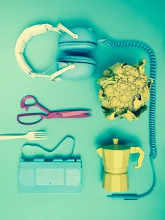 Headset, scissors, and teapot arranged on a wooden table