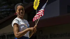 Woman in white t-shirt holding USA flag in San José on 4th of July