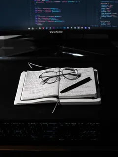 Black framed eyeglasses resting on white paper background