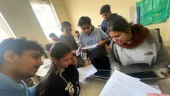 Students reading and discussing documents together in a classroom