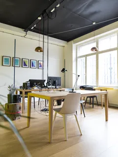 Empty brown chair next to table with lamp in cozy room