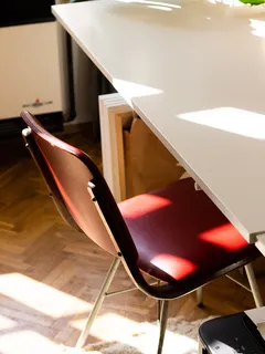 Red and gray chair next to white table in modern interior